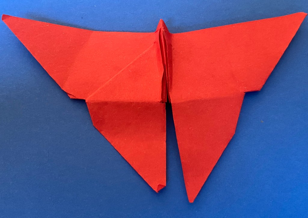 And orange origami butterfly on a blue background