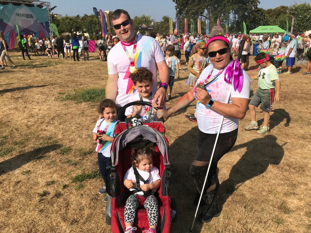 The Martinez/Bakker family posing after a color run. 